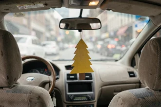 Arbre Magique jaune suspendu au rétroviseur intérieur d'une voiture en ville