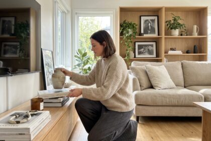 Femme élégante arrangeant des livres dans un salon moderne