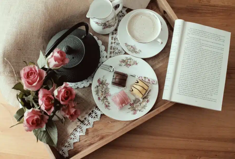 black kettle, plate, teacup, and saucer on brown tray