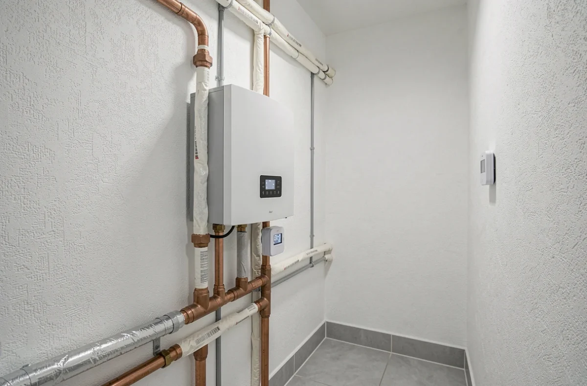 Tableau technique intérieur avec connexions de pompe à chaleur et panneau de contrôle mural