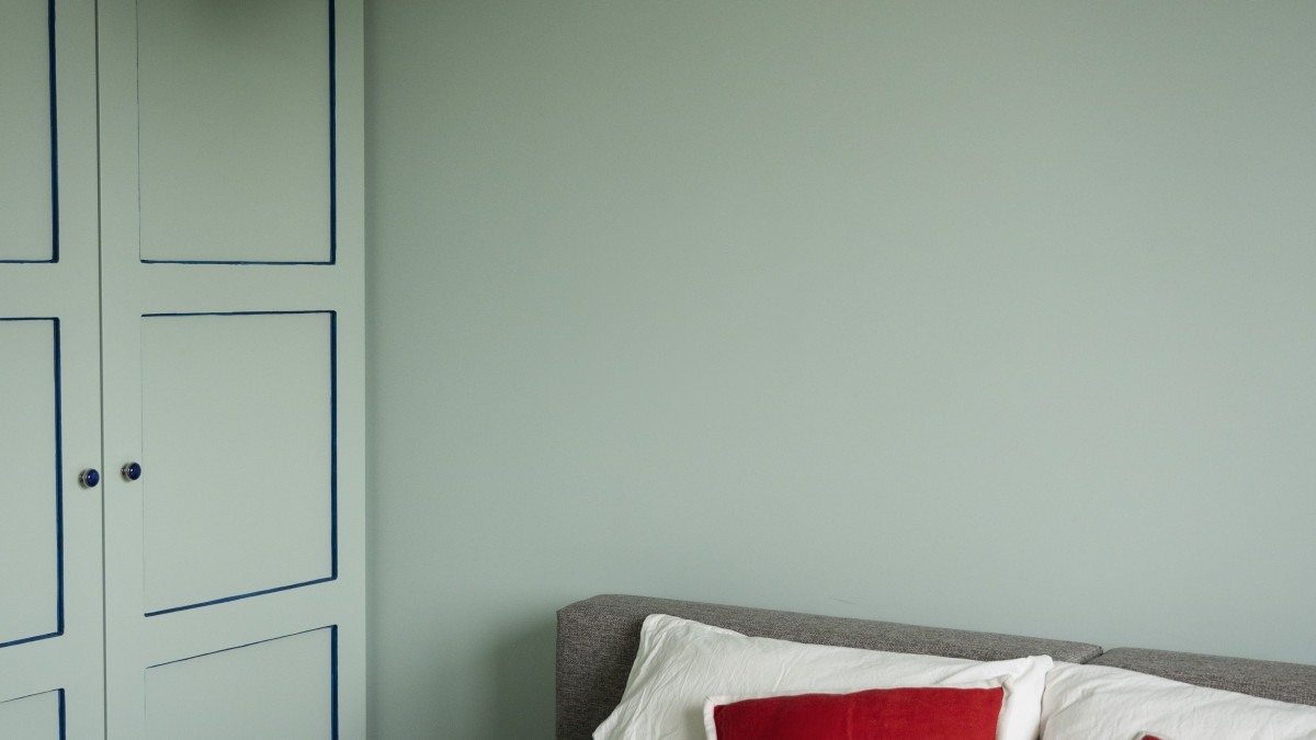 les murs d'une chambre sont peints en vert sauge