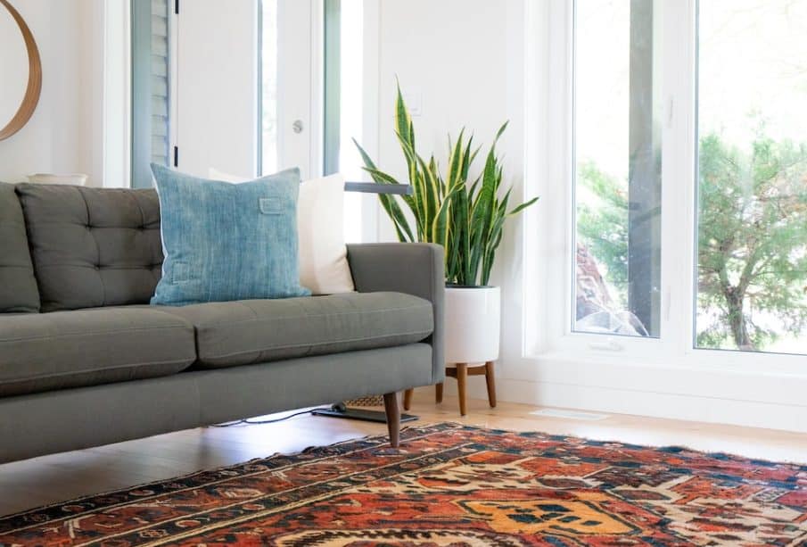 teal 2-seat couch and red area rug